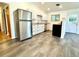 Updated kitchen featuring white cabinets, stainless steel appliances, and vinyl floors at 6040 W Elmhurst Dr, Littleton, CO 80128