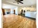 Bright open-concept living room with hardwood floors, fireplace, and seamless flow to the kitchen at 6040 W Elmhurst Dr, Littleton, CO 80128