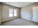 Bedroom with neutral paint, gray carpet, two large windows, and a white door at 8555 Hotchkiss St, Littleton, CO 80125
