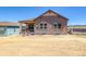 Rear exterior of this home showcasing the earth tone exterior and backyard at 8555 Hotchkiss St, Littleton, CO 80125