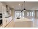 Bright kitchen with white cabinets, stainless appliances, a large island, and wood-look floors at 8555 Hotchkiss St, Littleton, CO 80125