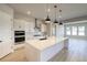 Modern kitchen featuring stainless steel appliances, white cabinets and a waterfall island at 8555 Hotchkiss St, Littleton, CO 80125