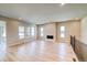 Spacious living room with wood-look floors, neutral paint, a fireplace, and lots of windows at 8555 Hotchkiss St, Littleton, CO 80125