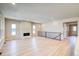 Open-concept living room with wood flooring, fireplace, and staircase with iron railings at 8555 Hotchkiss St, Littleton, CO 80125