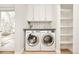 Modern laundry room featuring side-by-side washer and dryer, storage cabinets, and decorative backsplash at 1327 6Th St, Boulder, CO 80302