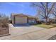 Suburban home featuring a well-maintained lawn, attached garage, a covered front porch, and a spacious driveway at 10142 Josephine St, Thornton, CO 80229