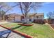 Landscaped front yard featuring a mature tree, complemented by brick edging and providing curb appeal to the property at 10142 Josephine St, Thornton, CO 80229