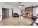 Living room with a cozy brick fireplace, ceiling fan, hardwood flooring, and a door to the backyard at 10142 Josephine St, Thornton, CO 80229