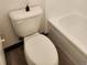 Clean bathroom featuring a white toilet and a tiled bathtub with modern fixtures at 2008 S Hannibal St # A, Aurora, CO 80013