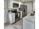 Well-lit kitchen featuring stainless steel appliances, white cabinets, and a modern countertop at 2008 S Hannibal St # A, Aurora, CO 80013