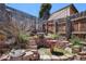 Charming backyard water feature made of brick and stone, surrounded by lush greenery and a wooden fence at 30819 Hilltop Dr, Evergreen, CO 80439