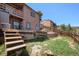 The backyard features tiered landscaping, wood retaining walls, and a blend of grass and natural terrain at 30819 Hilltop Dr, Evergreen, CO 80439