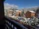 A balcony view of snow covered trees with warm colored mountain homes, accented by bright blue skies at 30819 Hilltop Dr, Evergreen, CO 80439