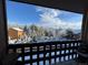 Balcony view overlooking the snowy residential complex surrounded by snow-covered trees and blue sky at 30819 Hilltop Dr, Evergreen, CO 80439