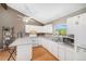 Bright kitchen boasts white cabinetry, modern appliances, and a breakfast bar at 30819 Hilltop Dr, Evergreen, CO 80439