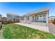 Backyard with a green lawn and patio featuring white adirondack chairs and an open field view at 872 S Flat Rock Way, Aurora, CO 80018