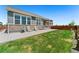Well-manicured backyard with a stone accented house, lovely green lawn, and ample patio space at 872 S Flat Rock Way, Aurora, CO 80018