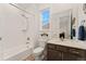 Bright bathroom featuring a shower-tub combo, single vanity, and natural light from the window at 872 S Flat Rock Way, Aurora, CO 80018
