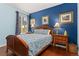 Cozy bedroom with blue accent wall, wooden furniture, and patterned bedding creating a relaxing space at 872 S Flat Rock Way, Aurora, CO 80018