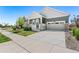 Residential street view showing a gray home with a two-car garage, front porch, and well-kept lawn at 872 S Flat Rock Way, Aurora, CO 80018