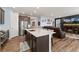 Spacious kitchen island with wooden cabinetry, open layout with living room with fireplace in background at 872 S Flat Rock Way, Aurora, CO 80018