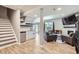 Open basement design with kitchenette, seating area, fireplace, and wood-look tile flooring at 5260 Morning Glory Pl, Highlands Ranch, CO 80130