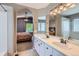 This bathroom showcases an opening into a bedroom, double vanity and tub/shower combo at 5260 Morning Glory Pl, Highlands Ranch, CO 80130