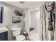 Stylish bathroom with subway tile shower, gray tile flooring, and black metal organizers at 5260 Morning Glory Pl, Highlands Ranch, CO 80130