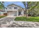 Charming two-story home boasts a brick facade, attached garage, and a welcoming front porch with a blue front door at 5260 Morning Glory Pl, Highlands Ranch, CO 80130