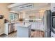 Well-lit kitchen with white cabinets, stainless steel appliances, modern countertops, and an island at 5260 Morning Glory Pl, Highlands Ranch, CO 80130