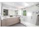 Bright bathroom featuring double vanity, a glass-enclosed shower, and a skylight providing natural light at 9673 Pinebrook St, Highlands Ranch, CO 80130