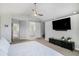 Bedroom features ceiling fan, a mounted TV, and sliding door access to the bathroom at 9673 Pinebrook St, Highlands Ranch, CO 80130