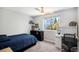 Cozy bedroom with a large window, fan, neutral carpet, and ample desk/storage space, perfect for relaxing at 9673 Pinebrook St, Highlands Ranch, CO 80130