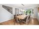 Bright dining room with a modern table set, wood floors, and large windows overlooking the front yard at 9673 Pinebrook St, Highlands Ranch, CO 80130