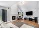 Bright living room with a vaulted ceiling, a white brick fireplace, hardwood floors, and modern decor at 9673 Pinebrook St, Highlands Ranch, CO 80130