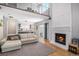 Spacious living room with a fireplace, a modern staircase, hardwood floors, and access to a modern kitchen at 9673 Pinebrook St, Highlands Ranch, CO 80130