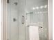 Modern walk-in shower with glass doors and white tiled walls; towel bar at 9673 Pinebrook St, Highlands Ranch, CO 80130