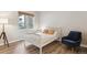 Bright bedroom featuring hardwood floors, a comfortable bed, and a cozy chair at 9692 W Coco Cir # 103, Littleton, CO 80128