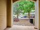 View from the doorway showcasing a landscaped parking area with mature trees and assigned parking spaces at 9692 W Coco Cir # 103, Littleton, CO 80128