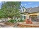 Exterior view of the Deer Creek clubhouse with a stone sign, lush landscaping, and mature trees at 9692 W Coco Cir # 103, Littleton, CO 80128