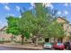 View of the front of the apartment complex with lush green trees at 9692 W Coco Cir # 103, Littleton, CO 80128