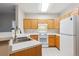 Bright kitchen with white countertops, wood cabinets, and white appliances at 9692 W Coco Cir # 103, Littleton, CO 80128