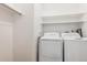 Laundry room featuring white washer and dryer units and storage shelving at 9692 W Coco Cir # 103, Littleton, CO 80128