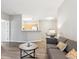 Open-concept living area with wood floors and a view into the dining space at 9692 W Coco Cir # 103, Littleton, CO 80128