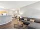 Living space with open access to the kitchen and dining area; wood floors at 9692 W Coco Cir # 103, Littleton, CO 80128