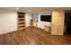 Unfinished basement with wooden floors, built-in shelves, and a window for natural light at 971 S Evanston Cir, Aurora, CO 80012