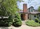 Charming home featuring a brick chimney, dormer windows, and lush landscaping for added curb appeal at 971 S Evanston Cir, Aurora, CO 80012