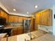 Functional kitchen featuring stainless steel appliances, wood cabinets, and tiled countertops at 971 S Evanston Cir, Aurora, CO 80012