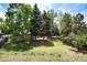 Beautiful, lush backyard featuring mature trees, green lawn, and a peaceful setting at 9837 E Aberdeen Ave, Englewood, CO 80111