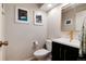 Stylish half bathroom with modern fixtures, updated lighting, and artwork enhancing the space at 9837 E Aberdeen Ave, Englewood, CO 80111